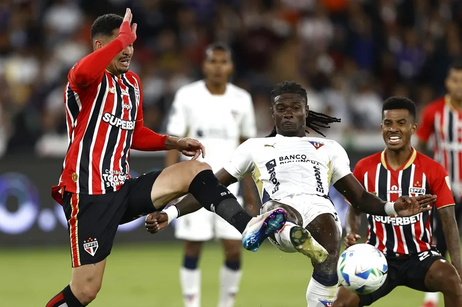 Ricardo Adé (c) de LDU Quito disputa el balón con Luciano da Rocha Neves (i) de Sao Paulo este jueves, en un partido por los cuartos de final de la Copa Libertadores en Quito (Ecuador). EFE/ José Jácome
