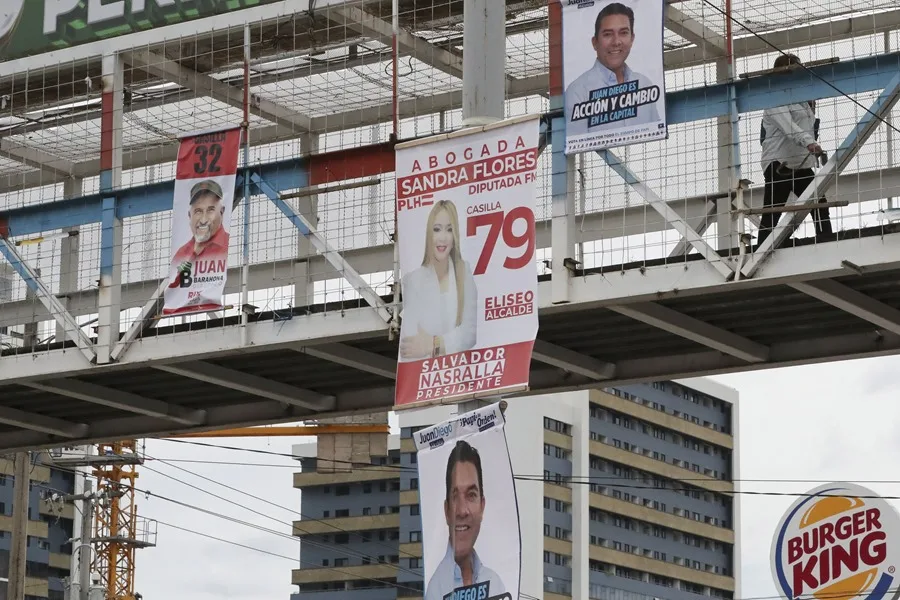 Una persona camina junto a carteles alusivos a la campaña electoral este lunes, en Tegucigalpa (Honduras). EFE/ STR