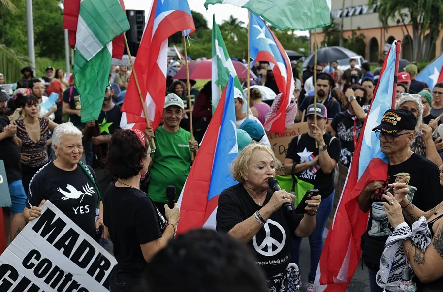 Sonia Santiago (c-abajo) del colectivo Madres Contra le Guerra se manifiesta en rechazo a las maniobras del Ejército de Estados Unidos en Puerto Rico, en Carolina (Puerto Rico). EFE/ Thais Llorca