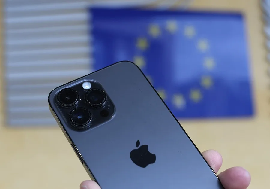 Apple pide la derogación de la ley de mercados digitales de la UE. En la imagen, Vista del logo de Apple en un iPhone frente al edificio de la Comisión Europea en Bruselas, Bélgica, en una imagen de archivo. EFE/EPA/OLIVIER HOSLET