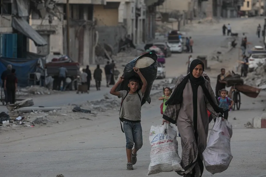 Palestinos desplazados evacuan una zona atacada por un ataque aéreo israelí en la ciudad de Gaza.