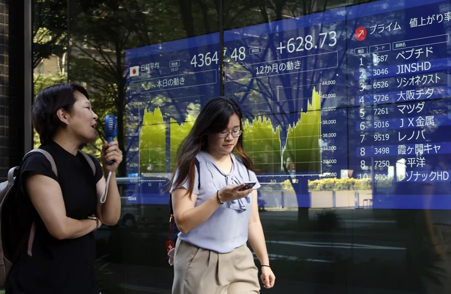 Fotografía de archivo de peatones pasando junto a un panel indicador de la bolsa de valores en Tokio, Japón, el 8 de septiembre de 2025. EFE/EPA/FRANCK ROBICHON