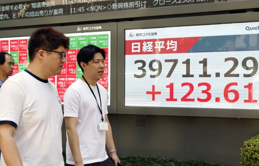 Fotografía de archivo de unos transeúntes pasando junto a un panel indicador del mercado bursátil en Tokio, Japón. EFE/EPA/FRANCK ROBICHON