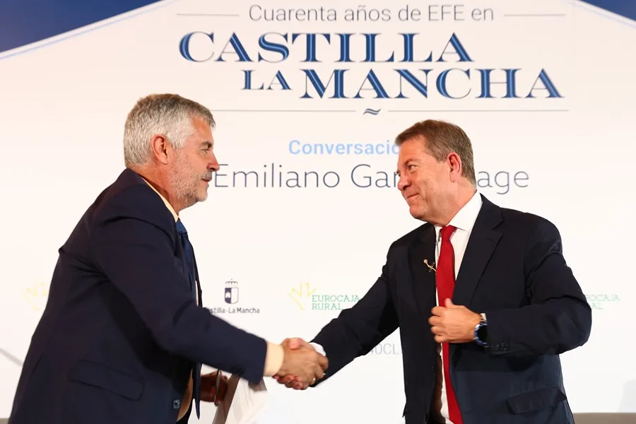 El presidente de la agencia EFE, Miguel Ángel Oliver (i), estrecha la mano del presidente de Castilla-La Mancha, Emiliano García-Page