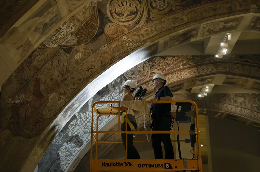 Dos técnicos analizan las pinturas del monasterio de Sijena en el Museo Nacional de Arte de Cataluña (MNAC).
