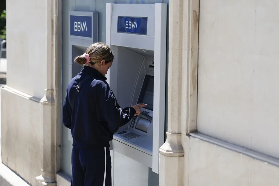 Una mujer saca dinero de un cajero del BBVA en Madrid.