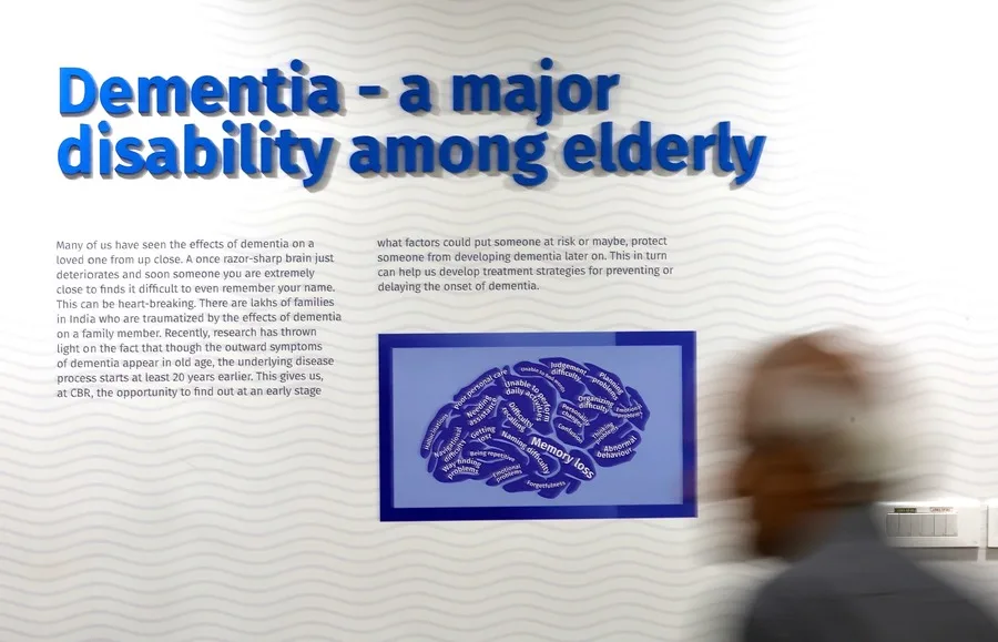 Un asistente camina frente a una valla publicitaria en un seminario de concienciación con motivo del Día Mundial del Alzheimer