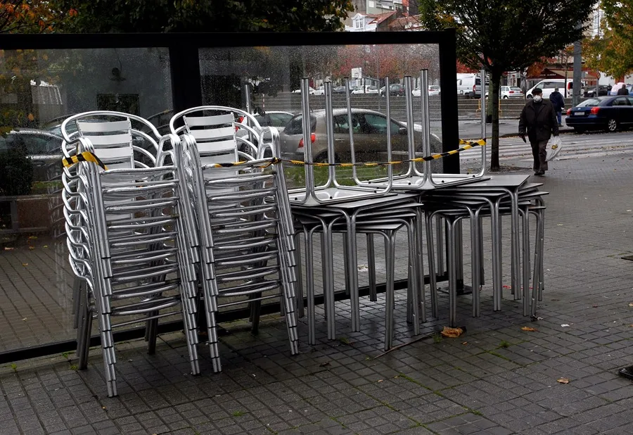 Vista de las sillas y las mesas apiladas en una terraza.