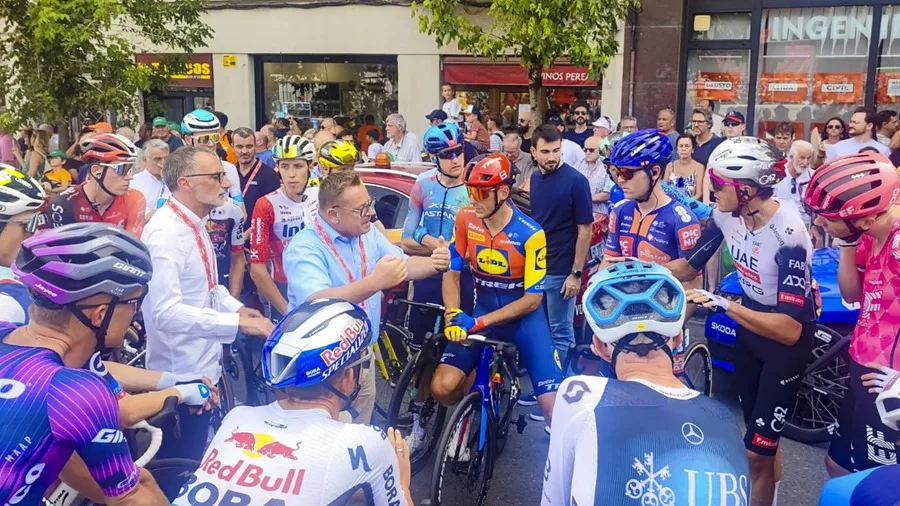 El presidente de los comisarios, Thierry Diederen (c), y el director técnico de la Vuelta, Kiko García (i), hablan con los ciclistas.