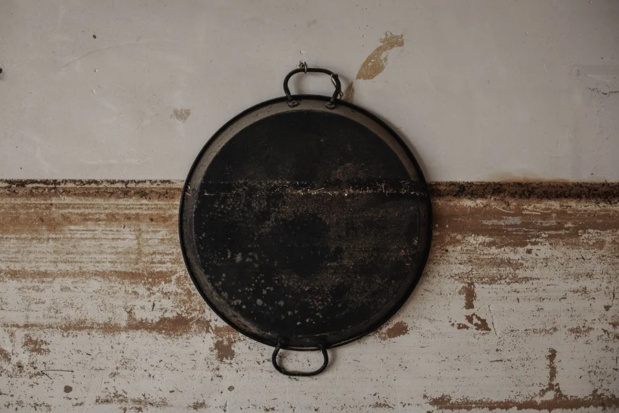 Marca de agua sobre la pared y una paella en una casa de La Torre, Valencia, tras el paso de la dana.