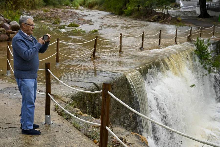 Una persona toma imágenes de un torrente de agua durante este lunes.