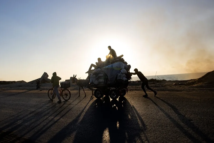 Palestinos desplazados del norte de la Franja de Gaza huyen con sus pertenencias por la calle Al-Rasheed 