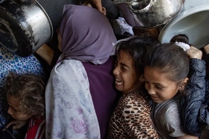 Cientos de palestinos desplazados se congregan frente al Comedor Benéfico Sokar en la ciudad de Gaza