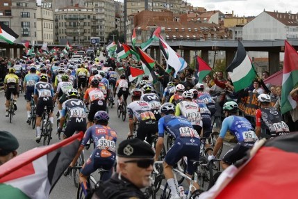 El pelotón pasa ante la protesta propalestina durante la etapa 16 de la Vuelta Ciclista a España