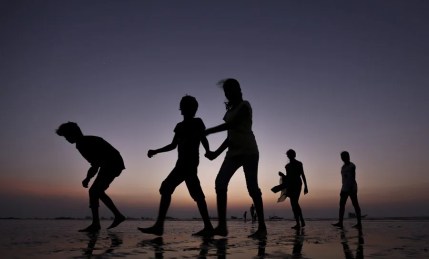 Unos jóvenes pasean en la orilla de una playa