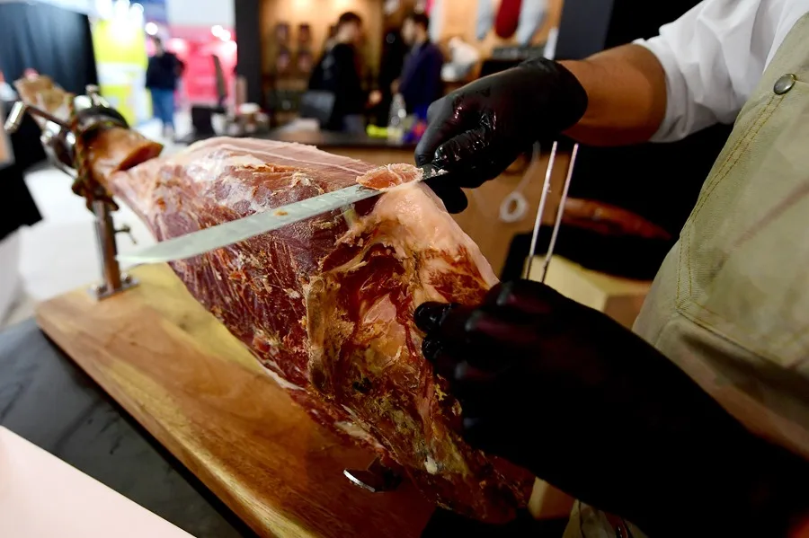 Una persona corta jamón serrano durante la inauguración de la feria ganadera y agroindustrial este viernes, en Montevideo
