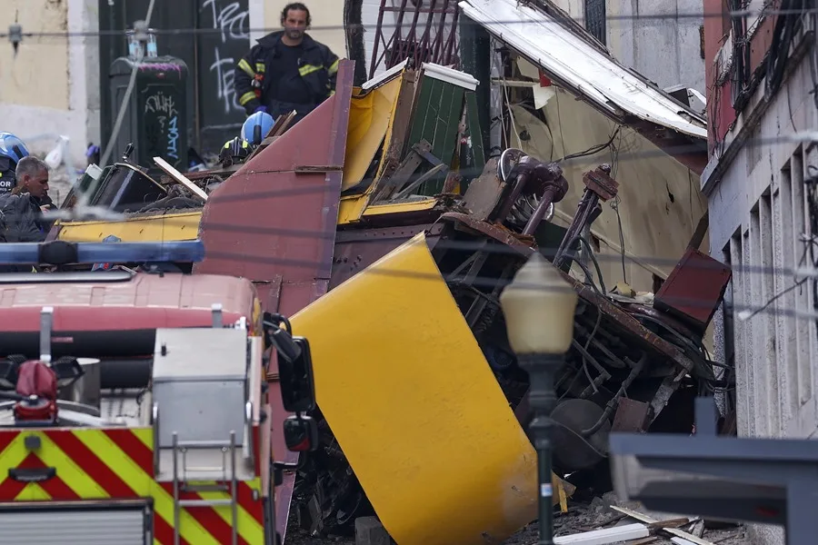 Rescatistas y bomberos trabajan en el lugar del descarrilamiento del funicular Gloria en Lisboa