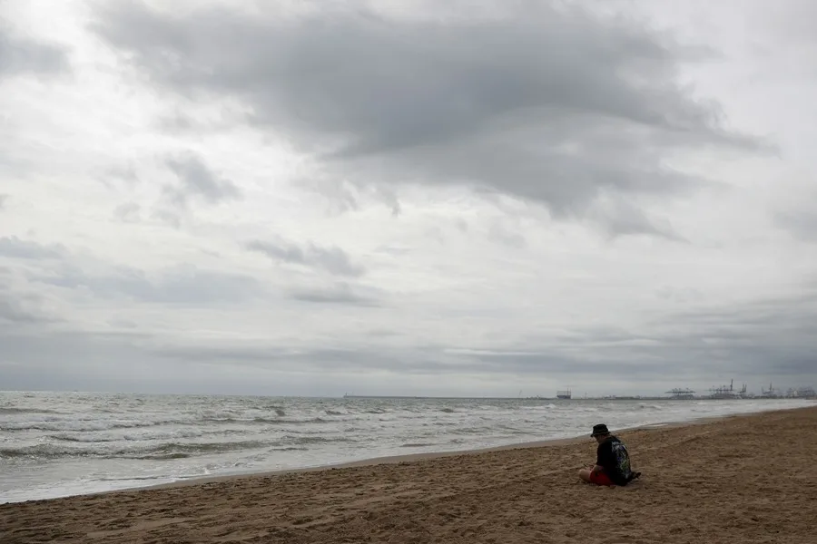 Una persona aguarda en la playa de la Patacona