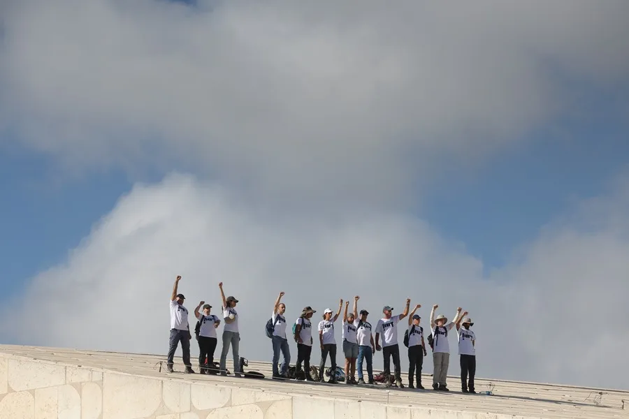 Manifestantes gesticulan en el tejado de la Biblioteca Nacional de Israel durante una manifestación de "Día de la Ira" para exigir al gobierno la firma de un acuerdo de liberación de rehenes y un alto el fuego en Jerusalén, Israel, 