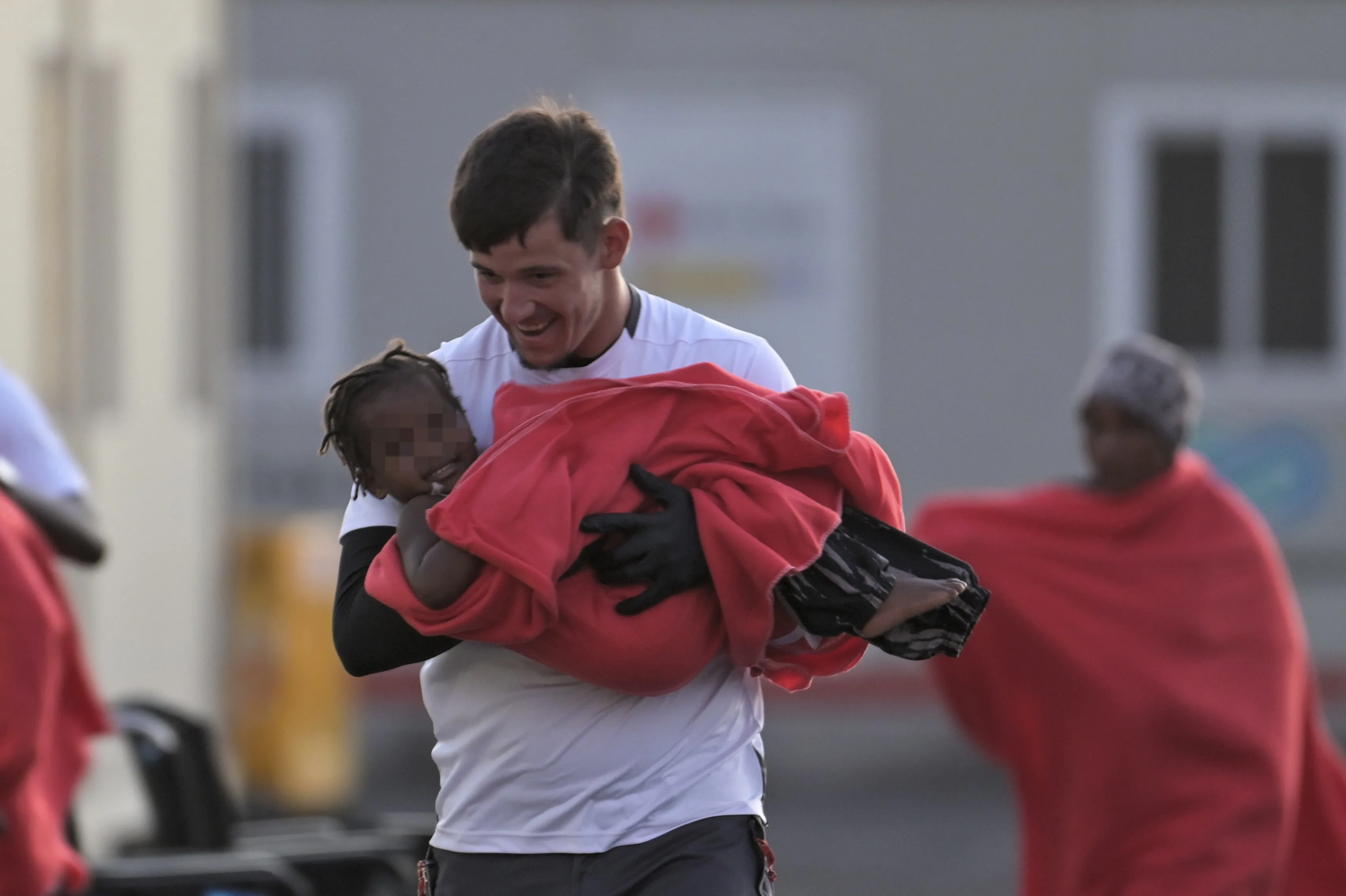 Un voluntario de Cruz Roja desembarca a una niña tras la llegada del cayuco a La Restinga. EFE/ Gelmert Finol