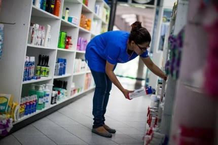 Una mujer organiza medicamentos en una farmacia
