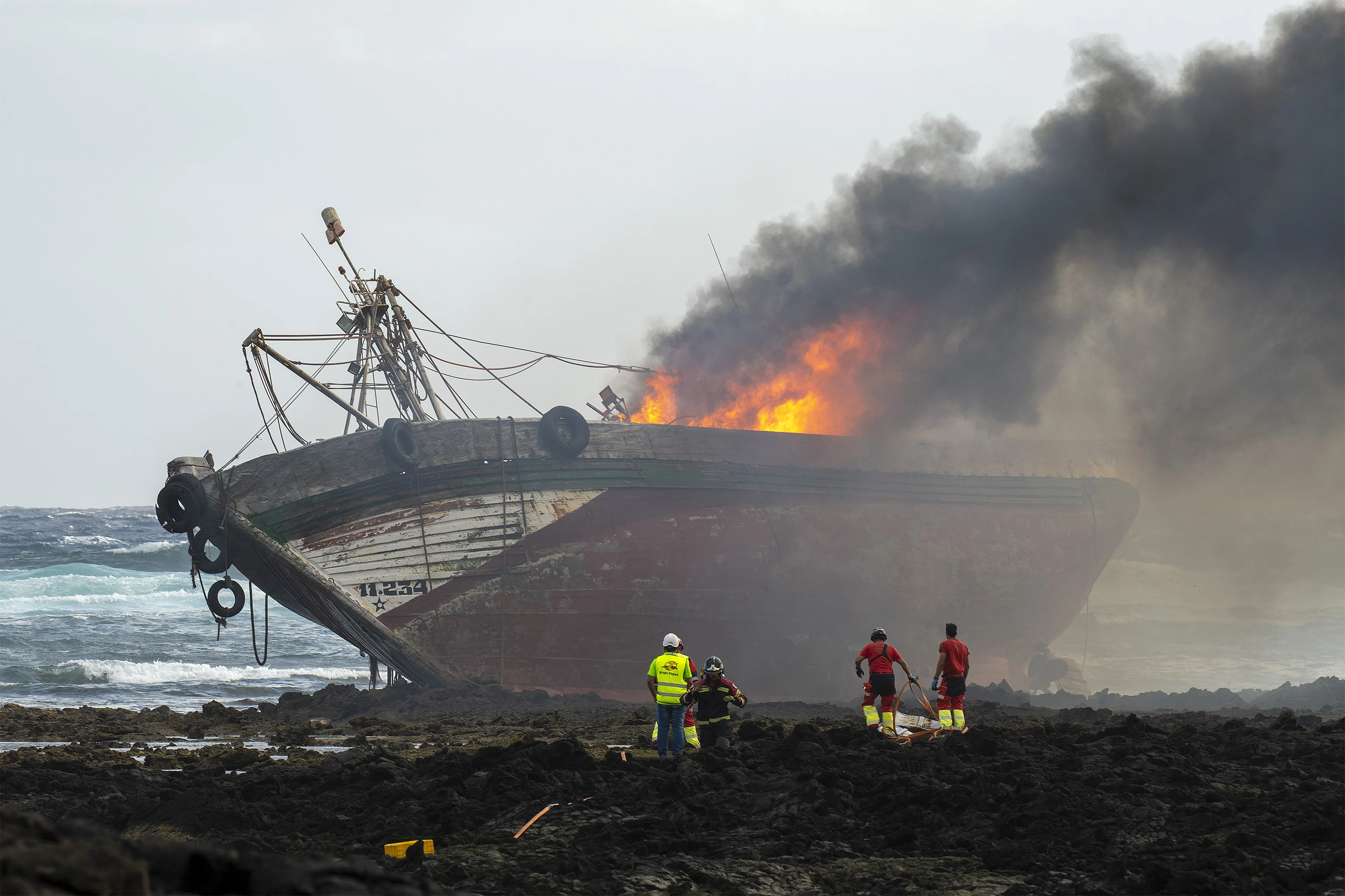 Momento en el que los bomberos de Lanzarote intenta controlar el incendio en el pesquero. EFE/ Adriel Perdomo