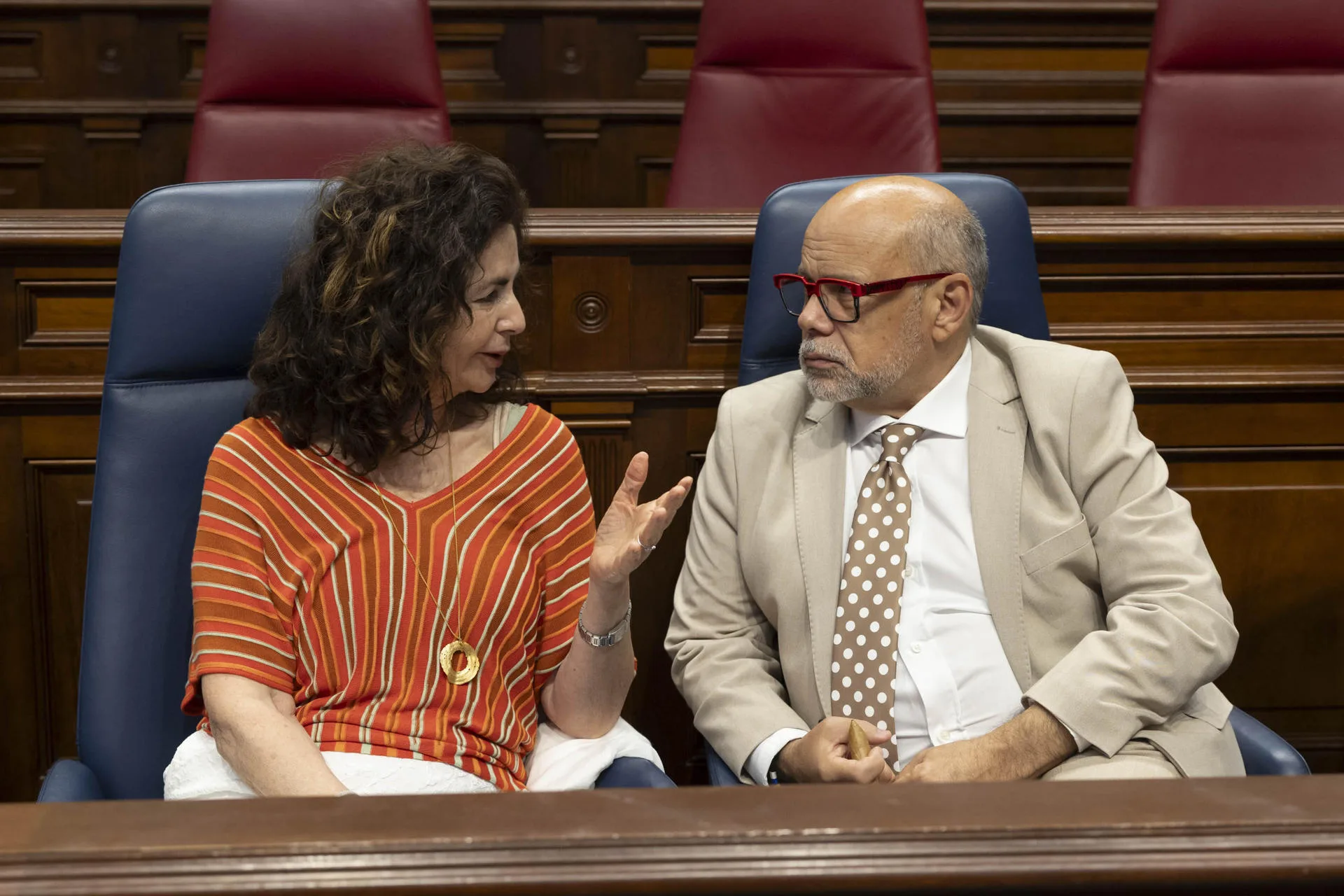 La consejera de Hacienda y Relaciones con Europa, Matilde Asián, (i) habla con el portavoz del grupo Nacionalista Canario, José Miguel Barragán, (d) antes del inicio del pleno del Parlamento de Canarias que se celebra este martes. EFE/Miguel Barreto