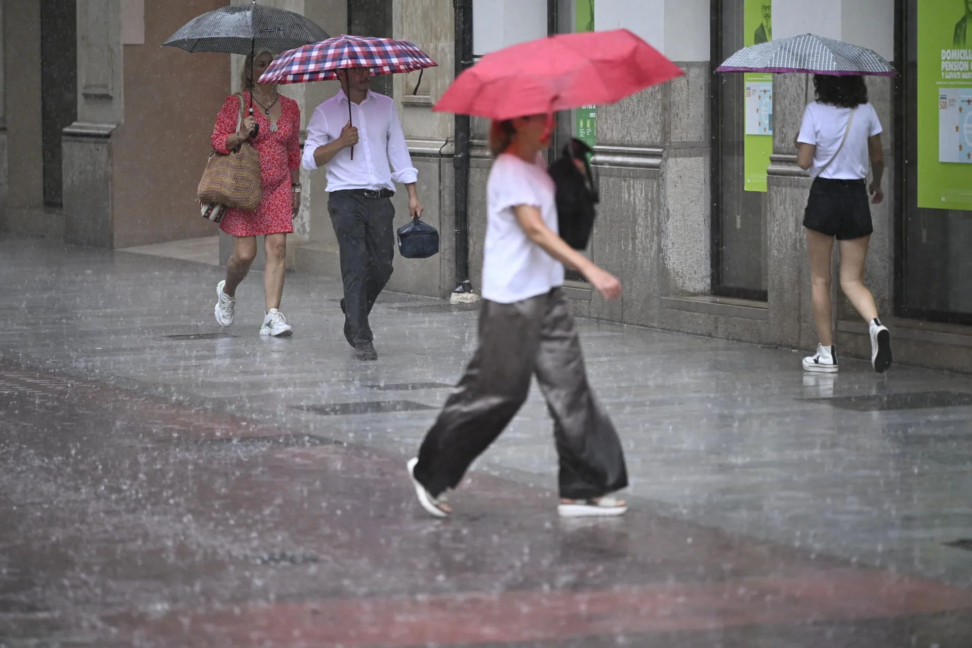 Varias personas caminan, este miércoles, por una calle de la ciudad de Castellón bajo una intensa lluvia. Archivo/EFE/Andreu Esteban