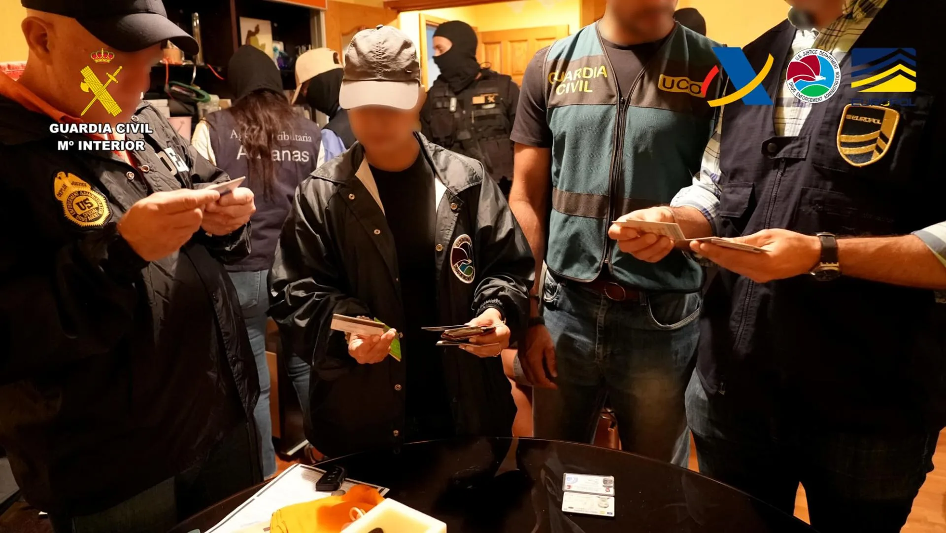 Agentes de los distintos cuerpos que han intervenido en la operación revisan documentación incautada en un registro, en una imagen facilitada por la Guardia Civil y la Agencia Tributaria. EFE