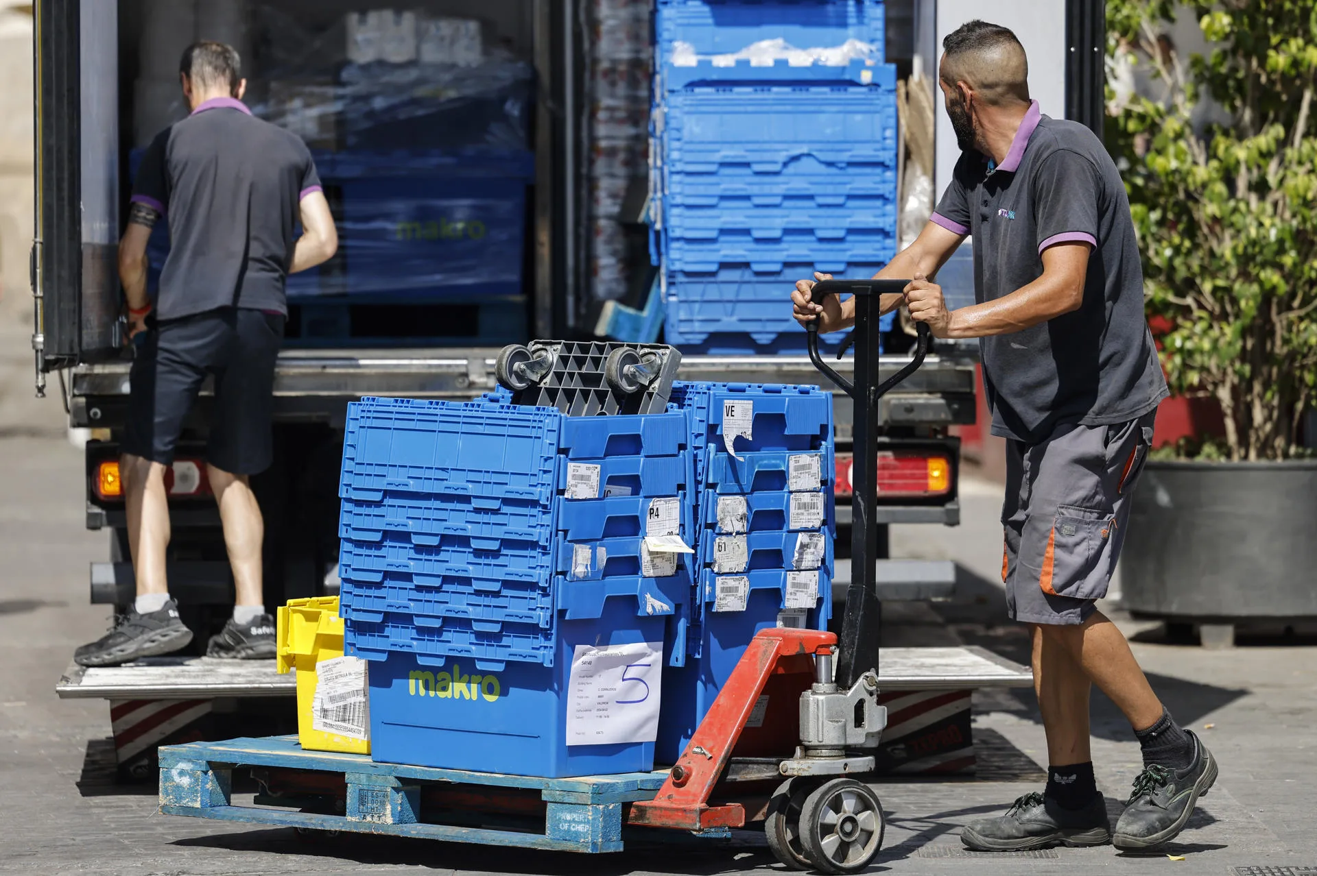 En la imagen, dos hombres realizan el reparto de un hipermercado en las calles de València. EFE/Ana Escobar