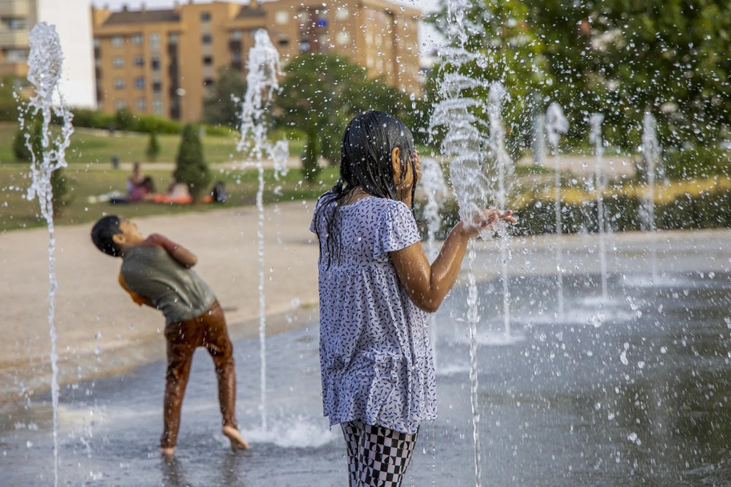 Unos niños se refrescan durante una de las olas de calor de este verano. EFE/Raquel Manzanares
