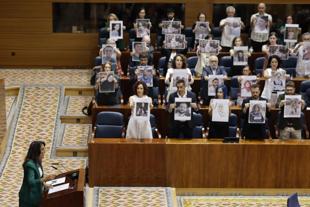Diputados regionales de Más Madrid muestran fotos de palestinos asesinados durante la intervención de la portavoz del grupo, Manuela Bergerot, durante la segunda sesión del debate del estado de la región en la Asamblea de Madrid este viernes.  EFE/ Sergio Pérez
