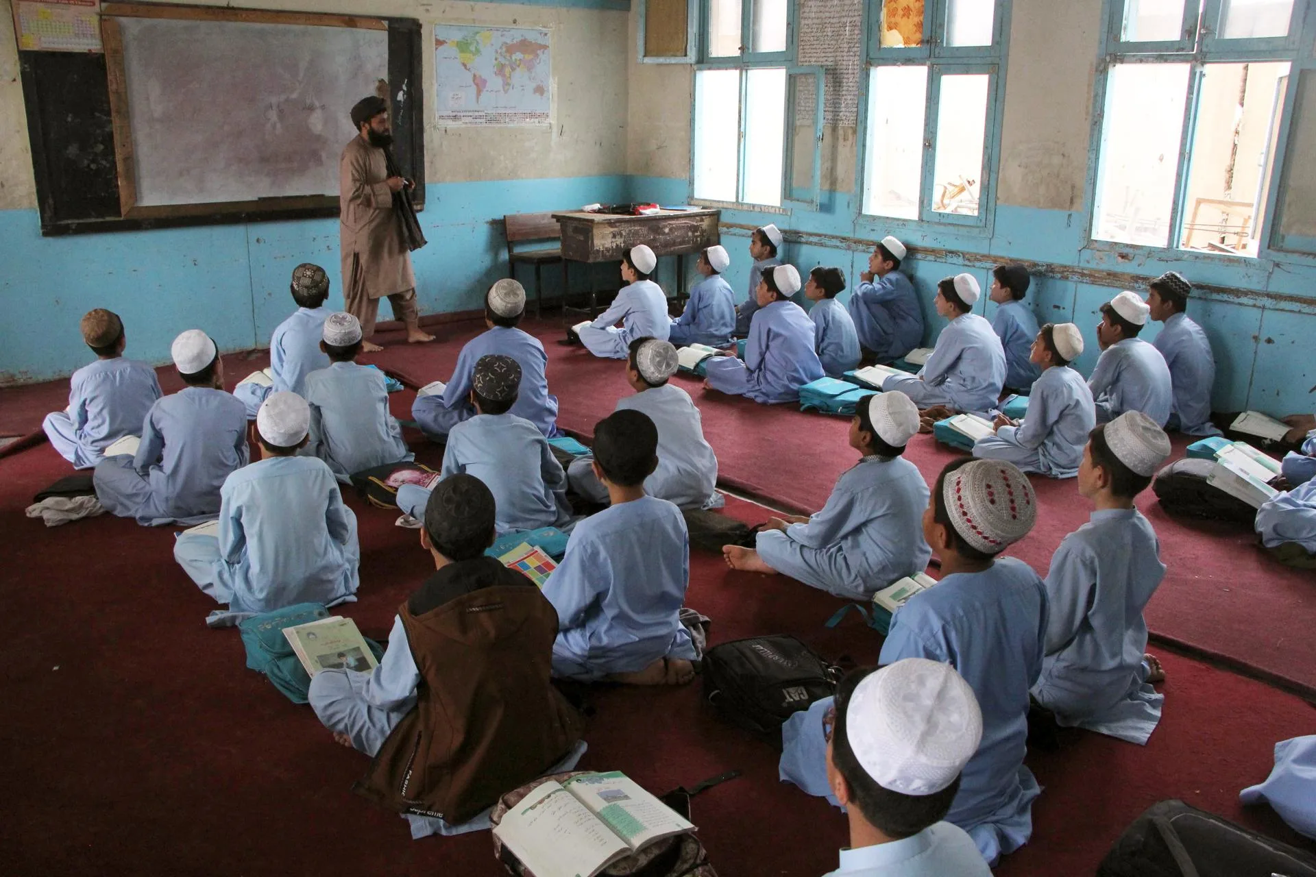 Estudiantes afganos con uniformes tradicionales asisten a una clase en una escuela pública en Kandahar, Afganistán, en una imagen de archivo. EFE/QUDRATULLAH RAZWAN