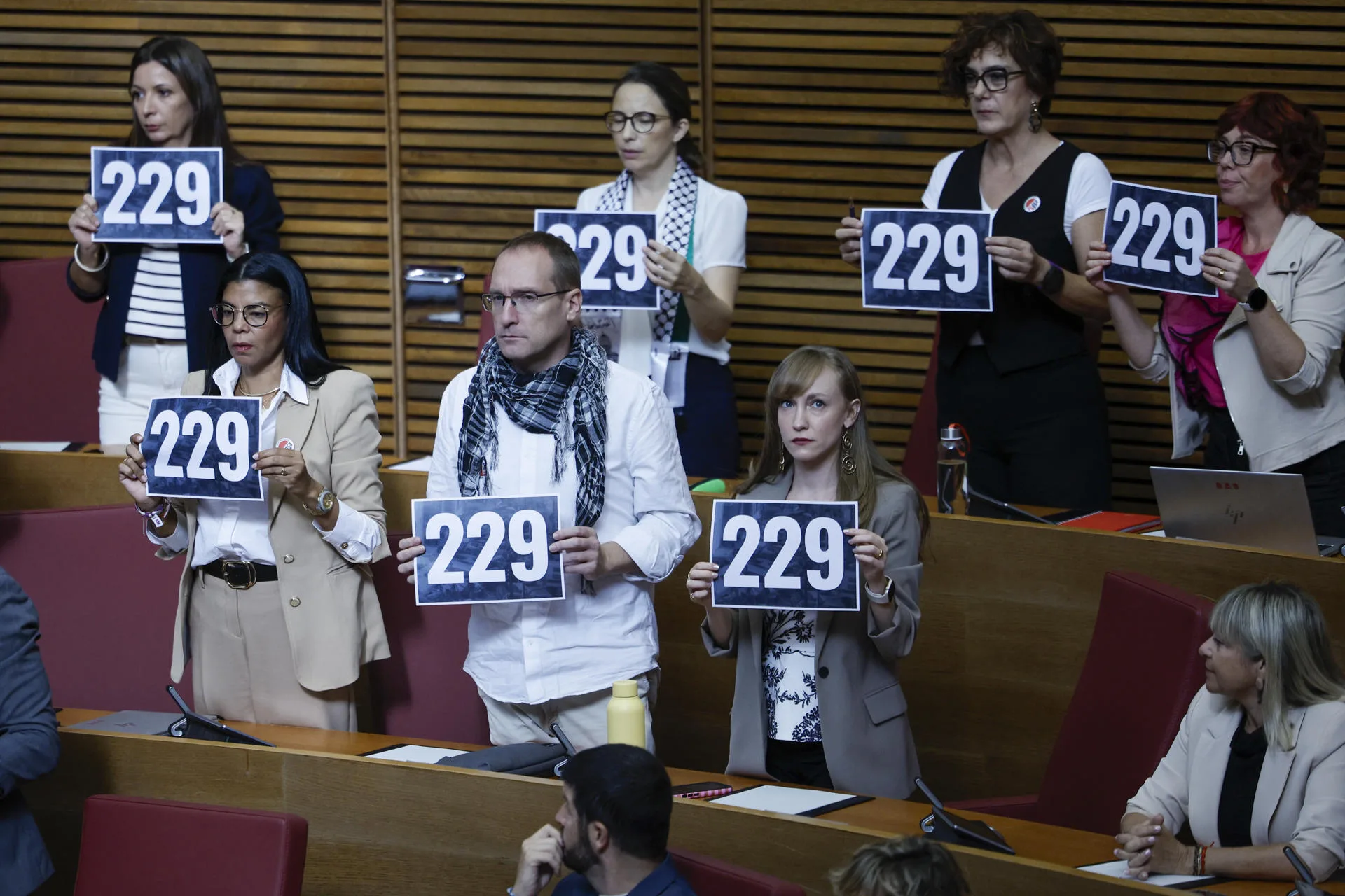 FOTODELDÍA GRAFCVA9414. VALENCIA, 23/09/2025.- Disputados de la oposición muestran carteles con el número de fallecidos en la dana durante el Debate parlamentario de Política General o sobre el estado de la Comunitat Valenciana, el primero después de la tragedia en la que murieron 229 personas. EFE/Biel Aliño