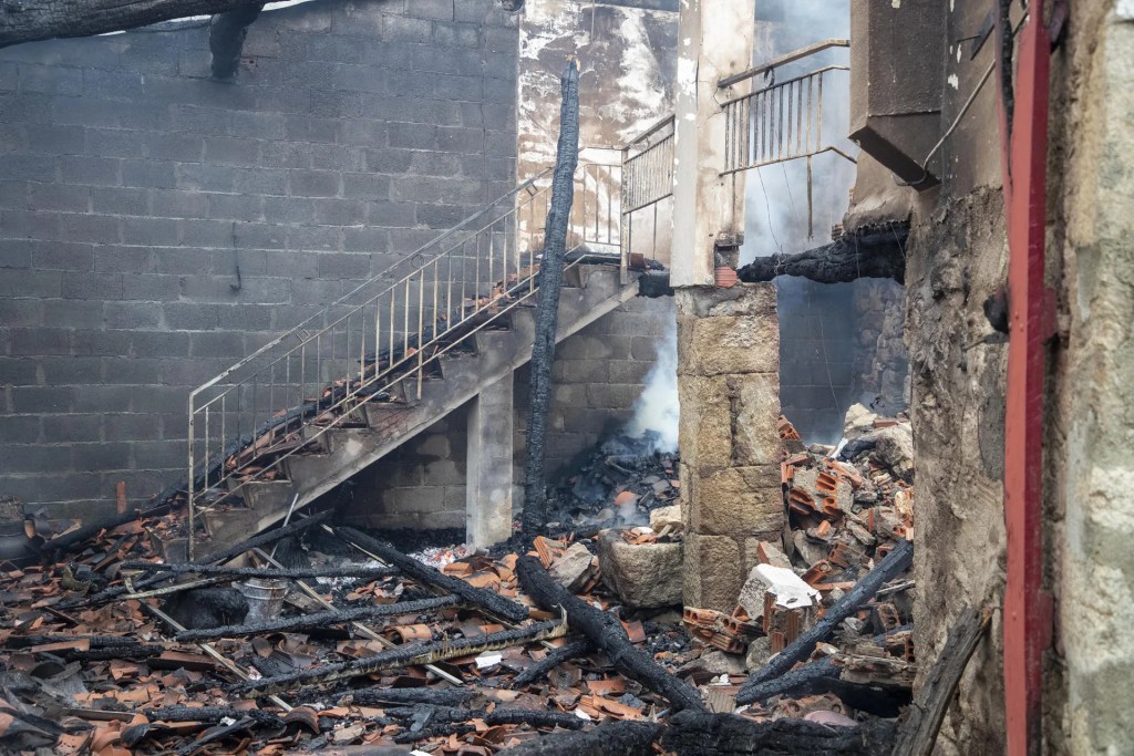 Estado de una casa tras el incendio que asola a los municipios lucenses de Pantón y Sober