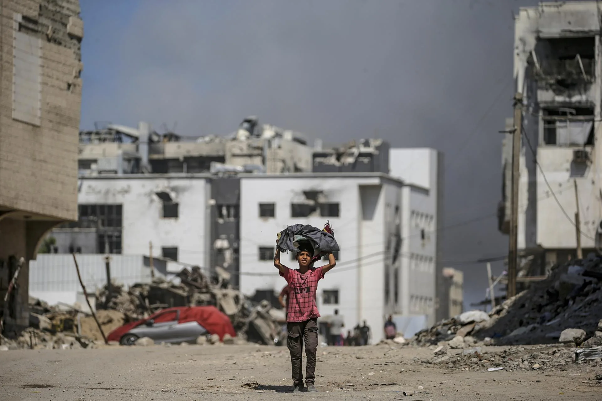 A Palestinian boy walks as smoke rises following an Israeli airstrike around Al-Shifa hospital in Gaza City, Gaza Strip, 28 September 2025. EFE-EPA/MOHAMMED SABER