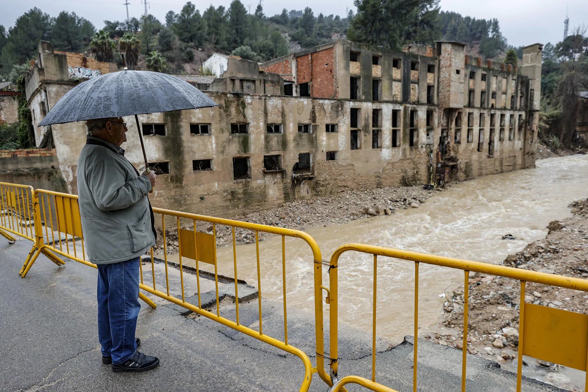 Un hombre observa la crecida del río Buñol a su paso por esta localidad valenciana debido a las abundantes lluvias. EFE/Manuel Bruque/Archivo