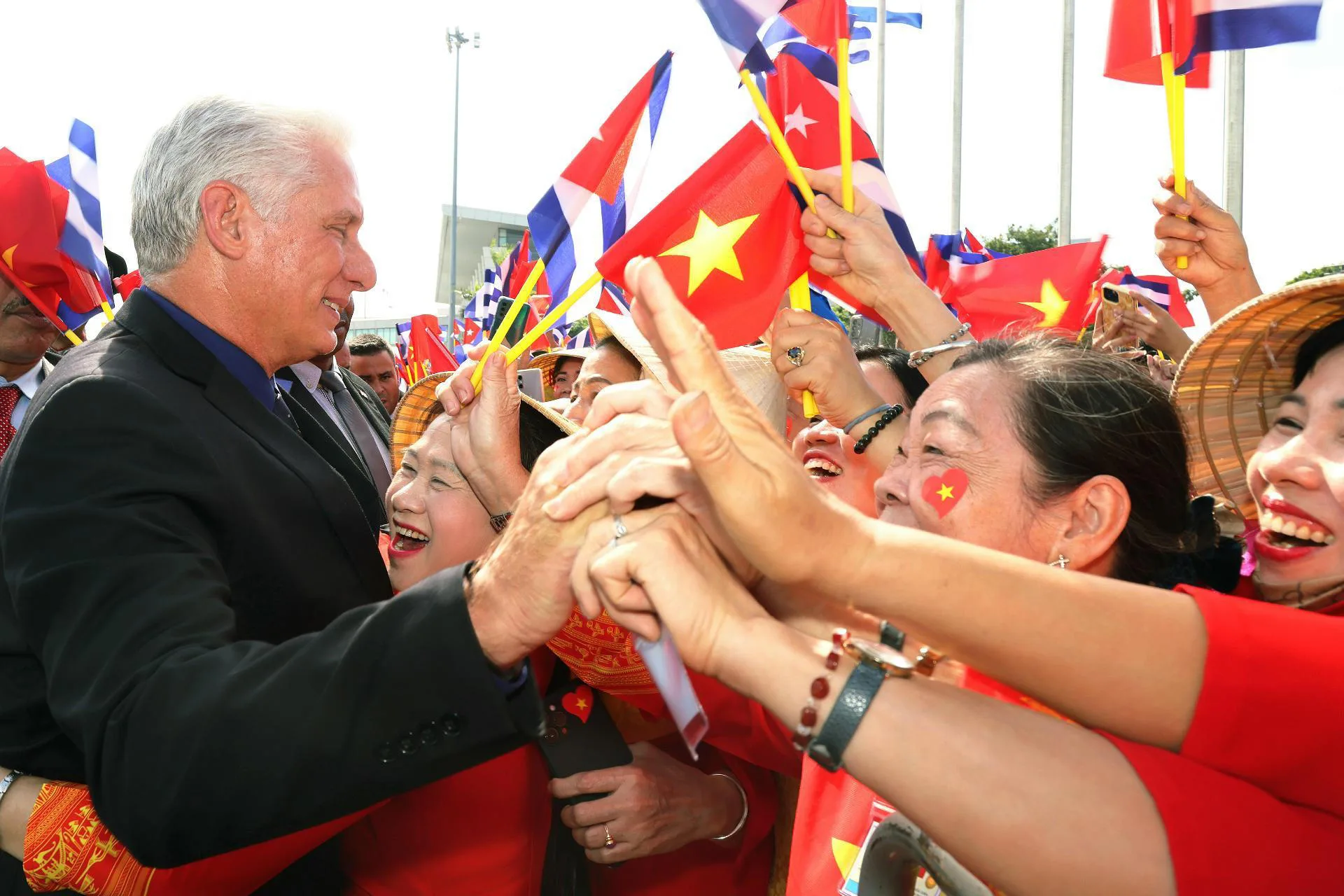 Fotografía cedida este domingo por la Presidencia de Cuba del mandatario Miguel Díaz-Canel (i), saludando a simpatizantes vietnamitas a su llegada a Hanoi (Vietnam). EFE/Alejandro Azcuy Presidencia de Cuba