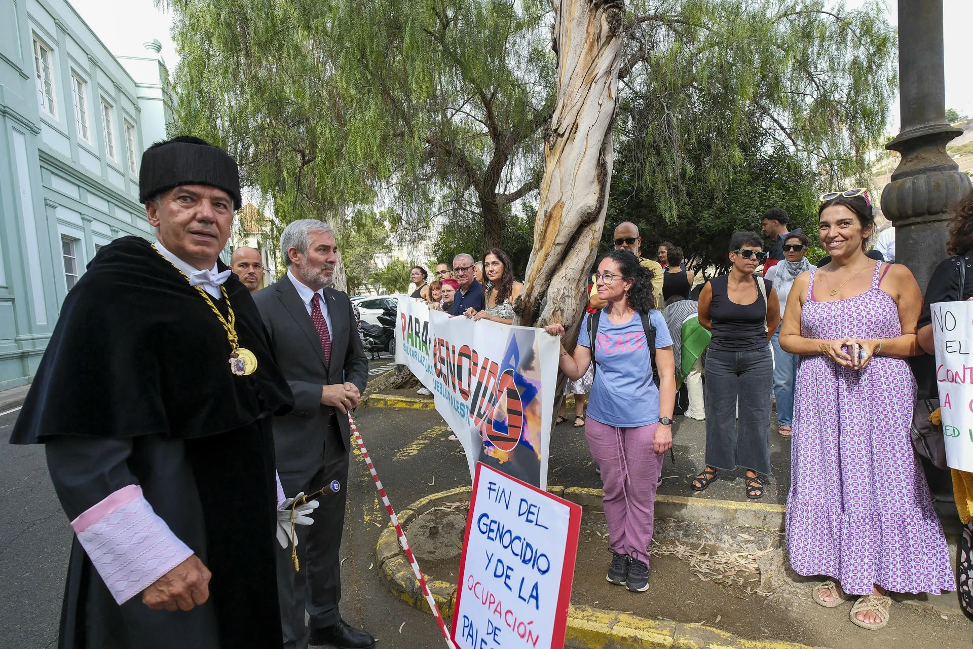 La Universidad de Las Palmas de Gran Canaria ha celebrado este miércoles el acto de apertura oficial del curso académico 2025-2026. En la imagen, el presidente Canarias, Fernando Clavijo (2i), y el rector de la institución, Lluís Serra (1i), conversan a la entrada del Paraninfo con un grupo de manifestantes que piden el final de la guerra en Gaza y acusan a Israel de genocidio. EFE/Ángel Medina G.