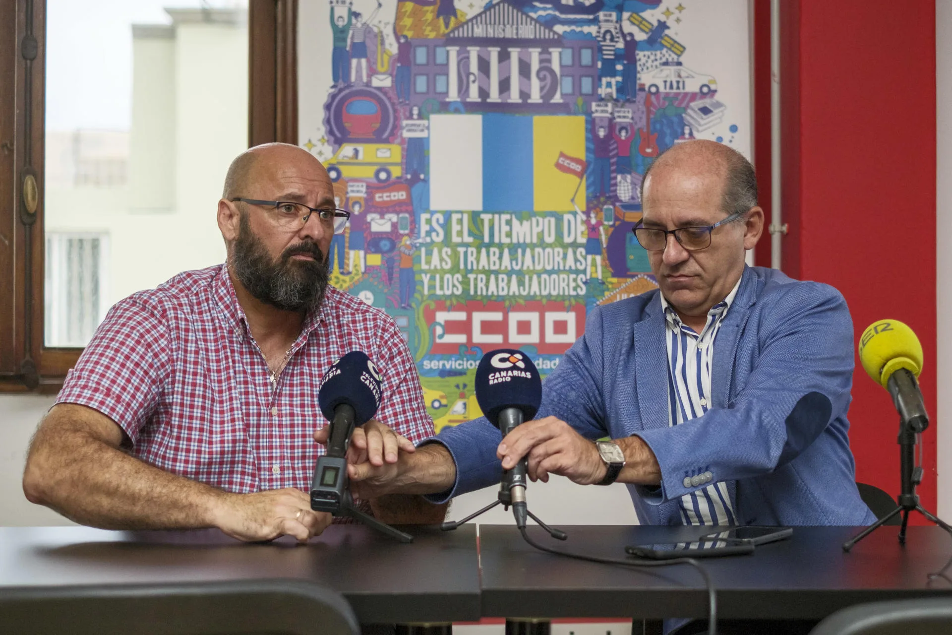 El secretario general de la Federación de Empresarios del Transporte en Canarias, José Angel Hernández (d), y el coordinador del Sector de Carreteras de la Federación de Servicios a la Ciudadanía de Comisiones Obreras en las islas, Santiago Domínguez (i), dan cuenta del acercamiento al que han llegado las dos partes. EFE/Ángel Medina G.