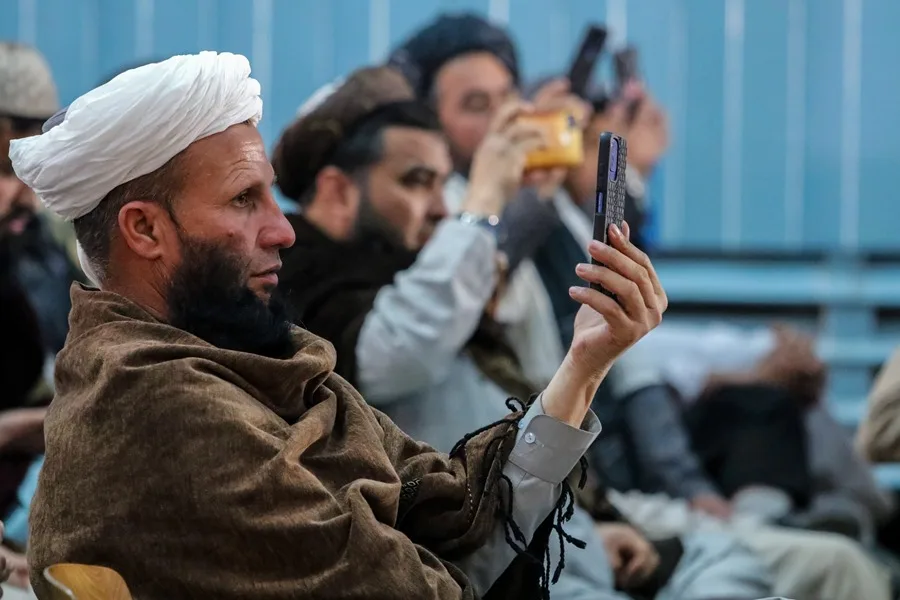 Un grupo de hombres en Kabul mira sus teléfonos móviles