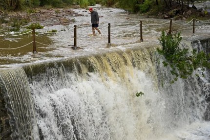 Un hombre cruza un badén inundable este lunes en Castellón.