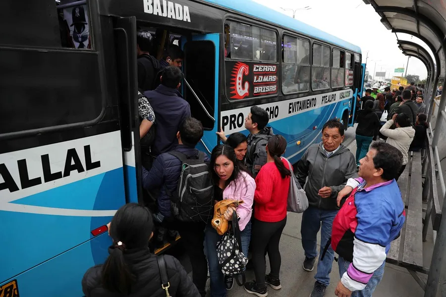 Personas intentan subir a un bus de servicio público en Lima (Perú). EFE/ Paolo Aguilar
