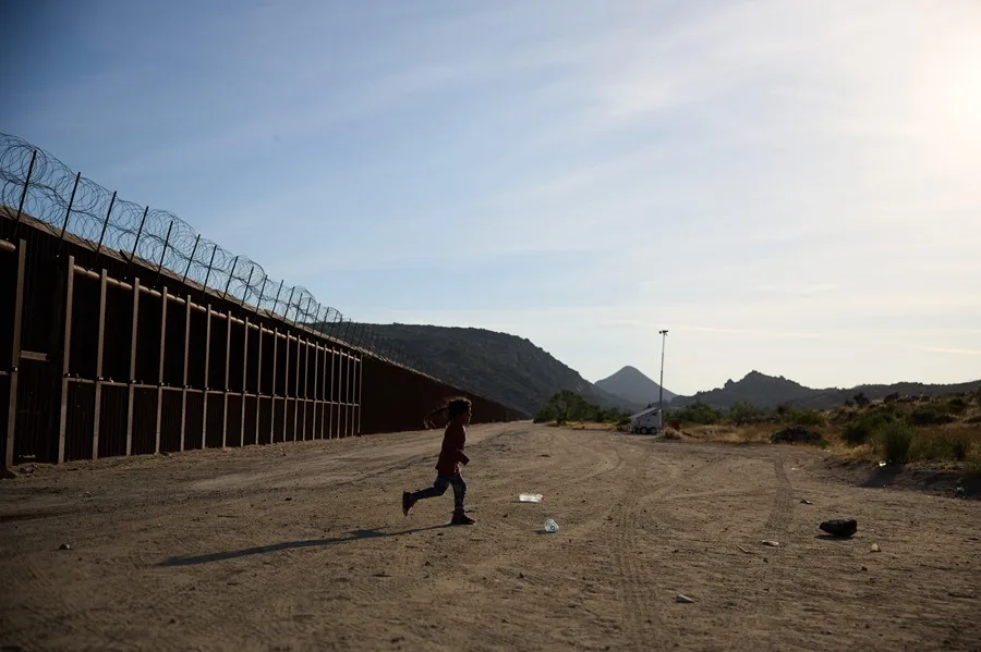 Fotografía de archivo de un niño junto al muro fronterizo mientras espera a la Patrulla Fronteriza de Estados Unidos tras cruzar la frontera entre Estados Unidos y México en Jacumba, California, EE.UU. EFE/EPA/ALLISON DINNER