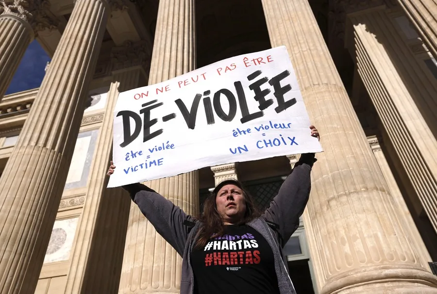 Una manifestante sostiene un cartel que dice "No puedes ser desviolada" frente al tribunal penal de Gard, en Nimes