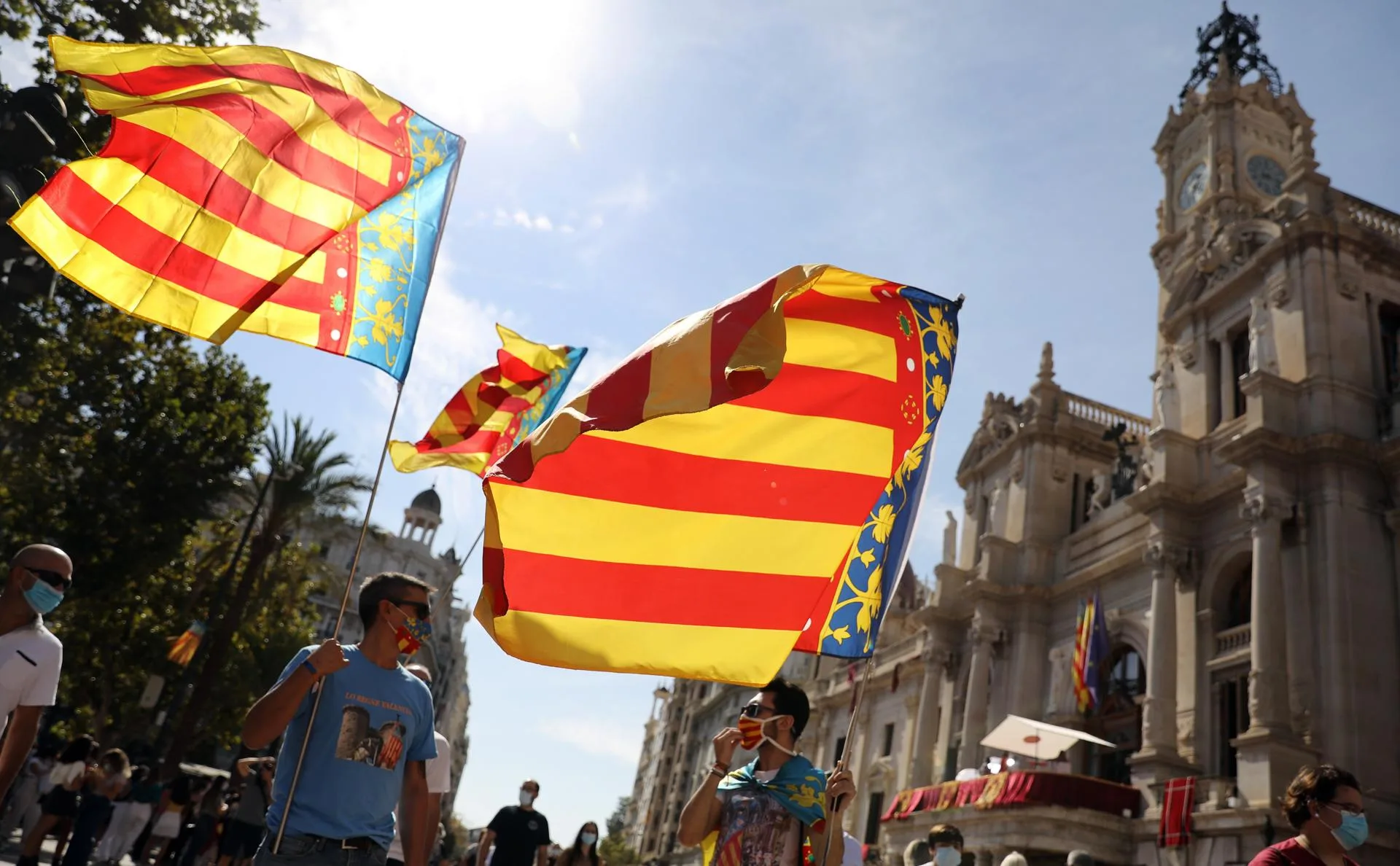 Unos jóvenes ondean la bandera valenciana bajo el Ayuntamiento de València el 9 d'Octubre anterior. EFE/Ana Escobar
