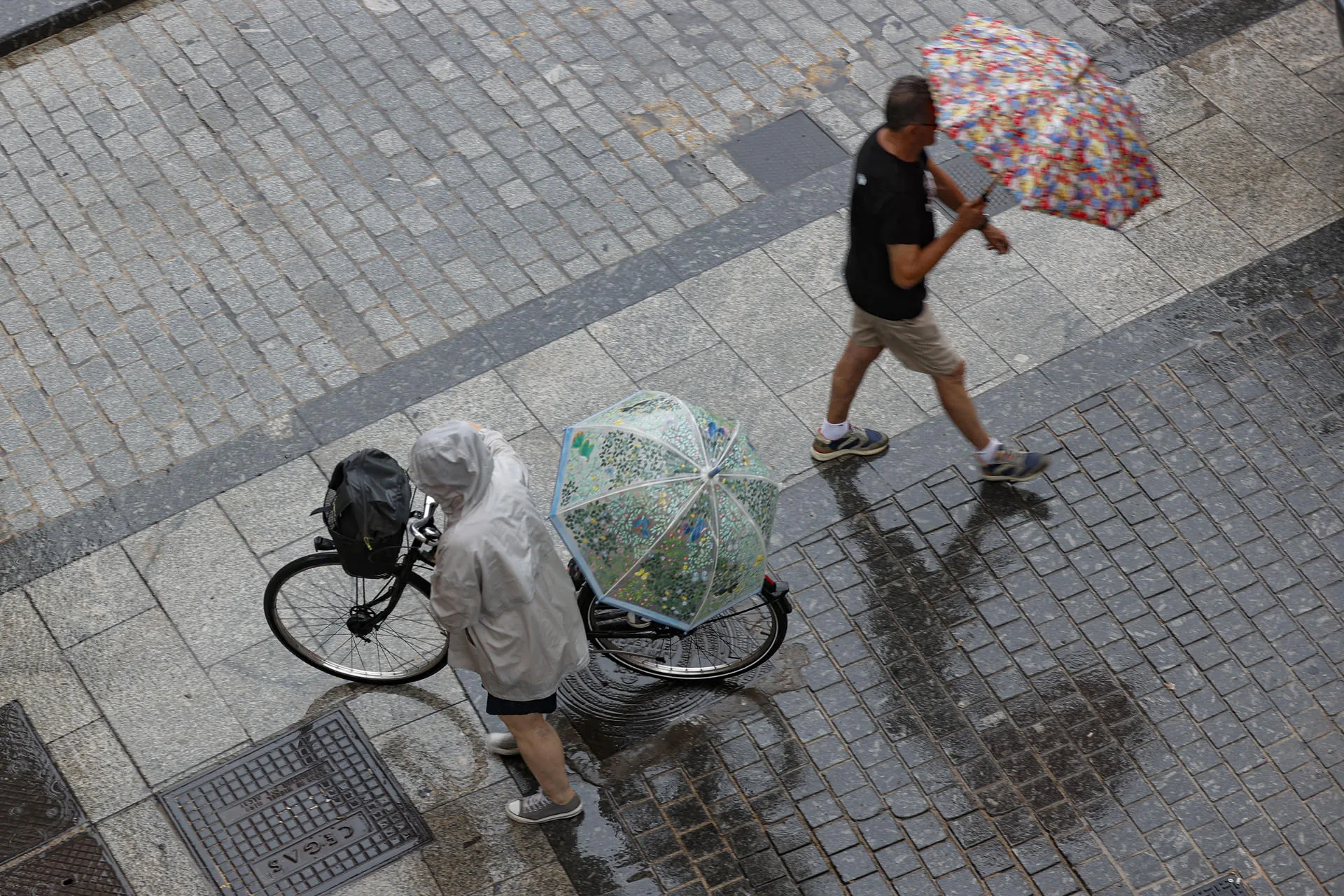 En la imagen de archivo, dos personas bajo la lluvia en una calle de Valencia. EFE/Manuel Bruque