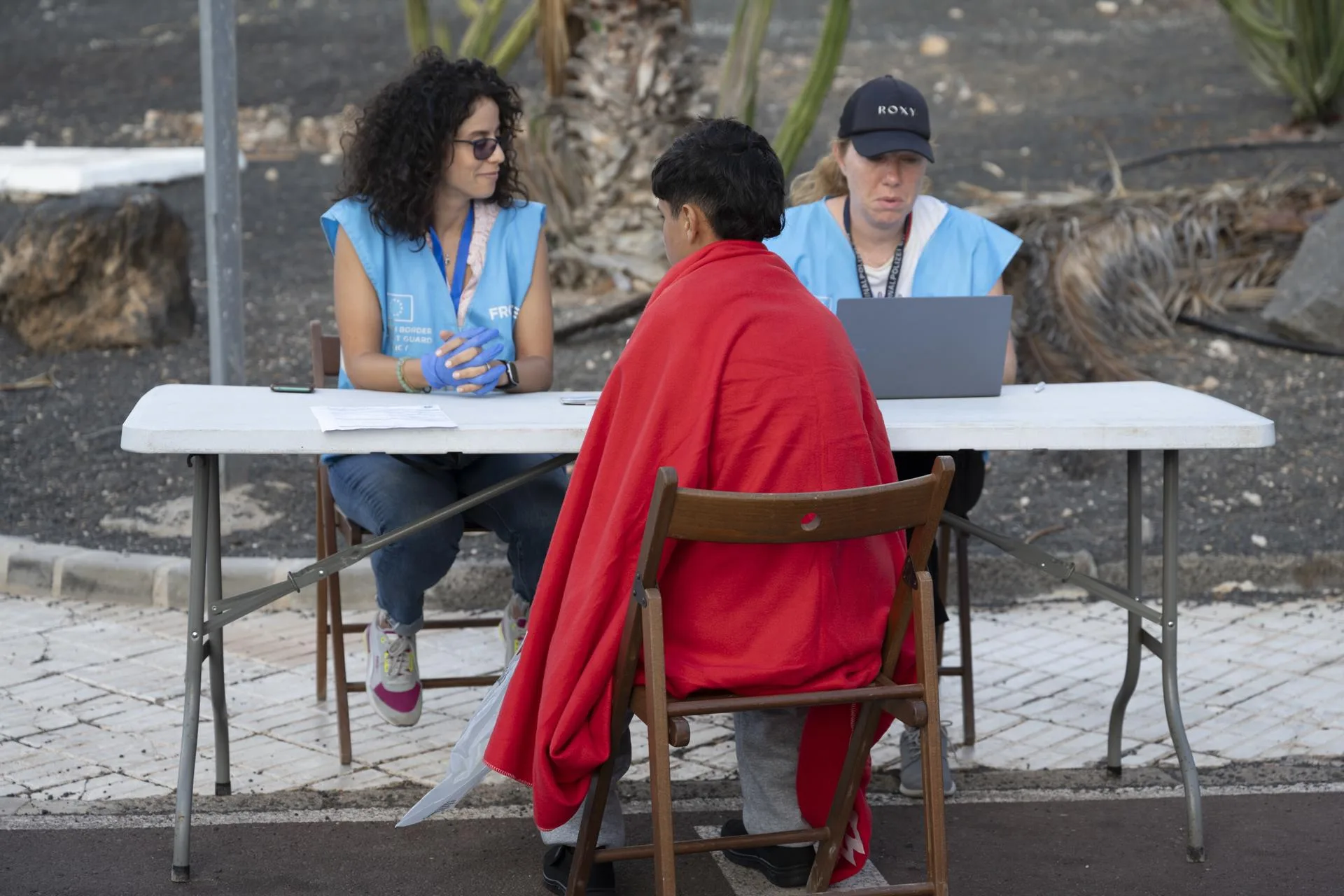 Foto de archivo de dos agentes de Frontex entrevistando a un menor poco después ed llegar en una neumática a Costa Teguise (Lanzarote). EFE/ Adriel Perdomo