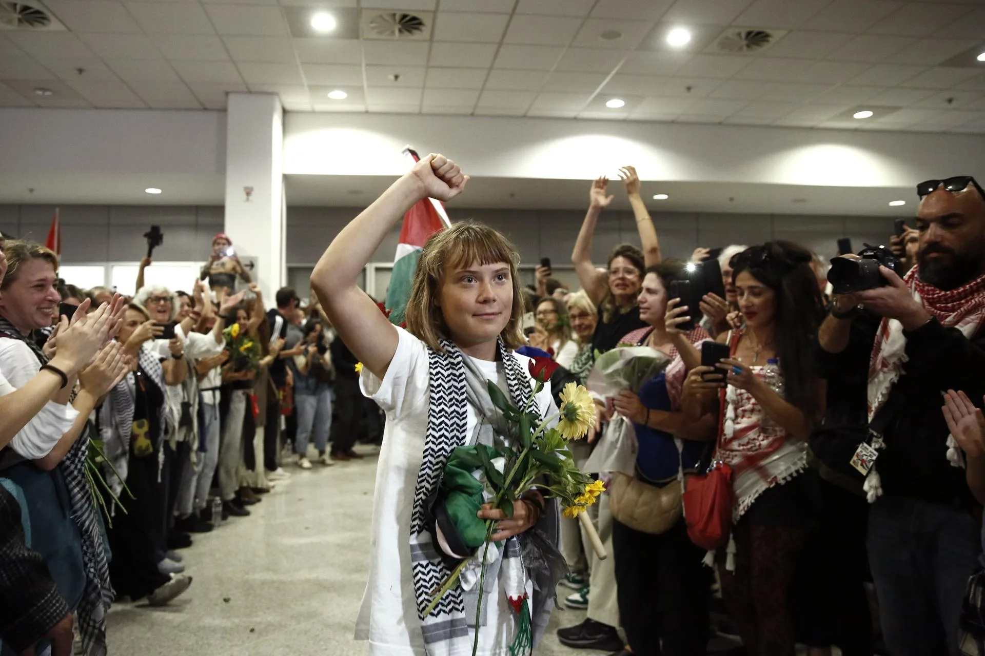 La activista sueca Greta Thunberg levanta el puño al llegar entre 134 ciudadanos de 15 países europeos, incluidos 27 ciudadanos griegos, al aeropuerto internacional griego Eleftherios Venizelos en Spata, cerca de Atenas, Grecia. EFE/YANNIS KOLESIDIS