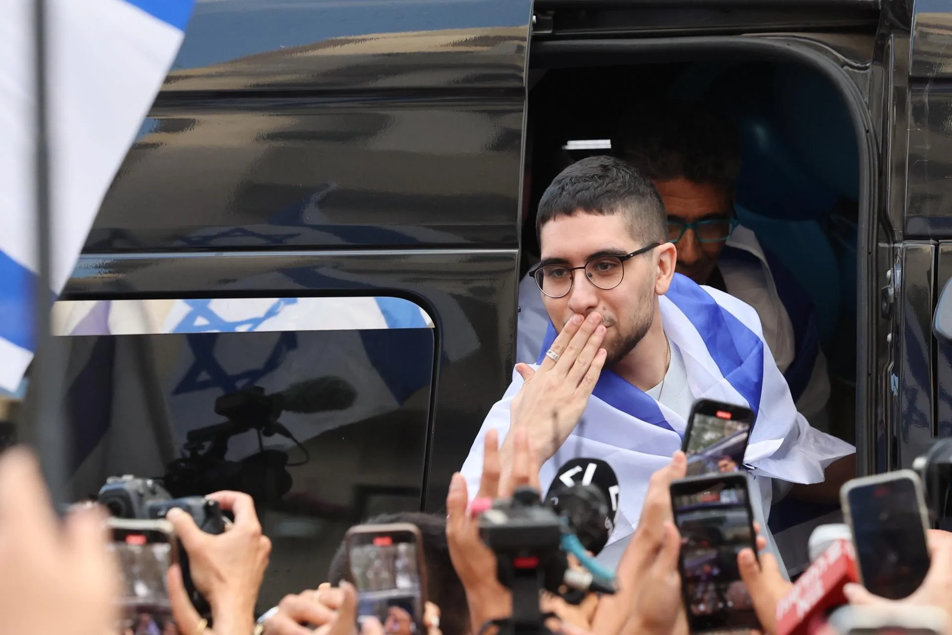 Kefar Sava (Israel), 26/10/2025.- El rehén israelí liberado Evyatar David saluda a las multitudes a su regreso a su hogar después de completar el período de hospitalización y tratamiento, en Kfar Sava, Israel, 26 de octubre de 2025. Evyatar David fue secuestrado por Hamas del festival de música Nova en la frontera de Gaza el 07 de octubre de 2023 y liberado durante un acuerdo de alto el fuego entre Hamas e Israel. Los cuerpos de 13 rehenes permanecen en cautiverio de Hamas. EFE/EPA/ABIR SULTAN